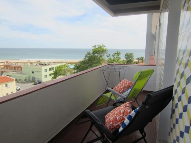 two chairs on a balcony with a view of the ocean at Alvor Torralta Apartment in Alvor