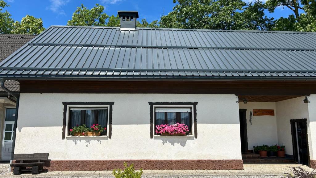 a white house with two windows with flowers at Apartments Vila Ančka in Tržič