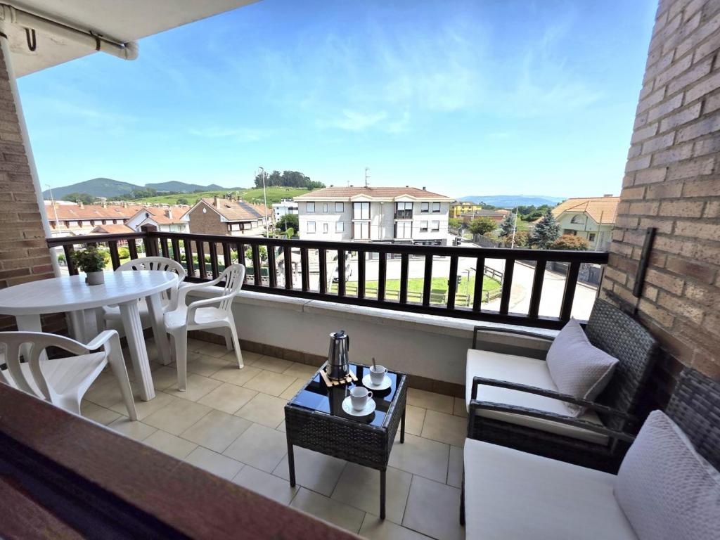 a balcony with a table and chairs and a table at Apartamento Viento y Marea 20811 in Argoños