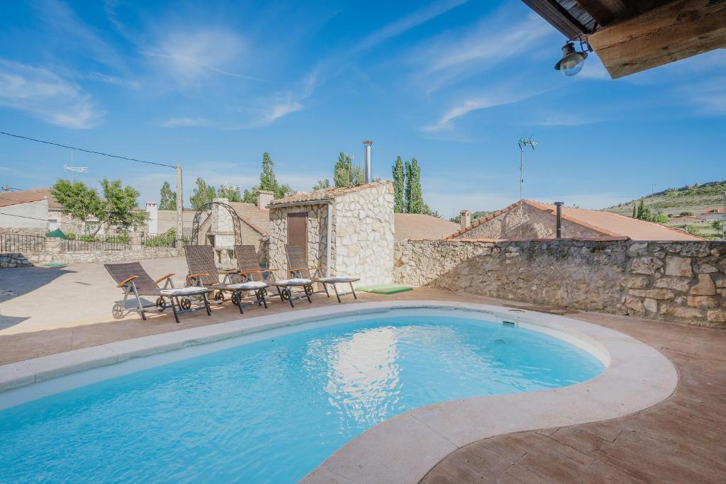 a large swimming pool with a table and a picnic table at Peña in Castro de Fuentidueña