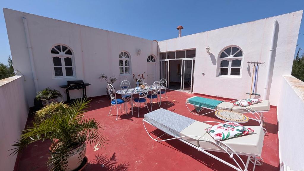 a patio with chairs and tables on a building at Dar Mozart in Essaouira