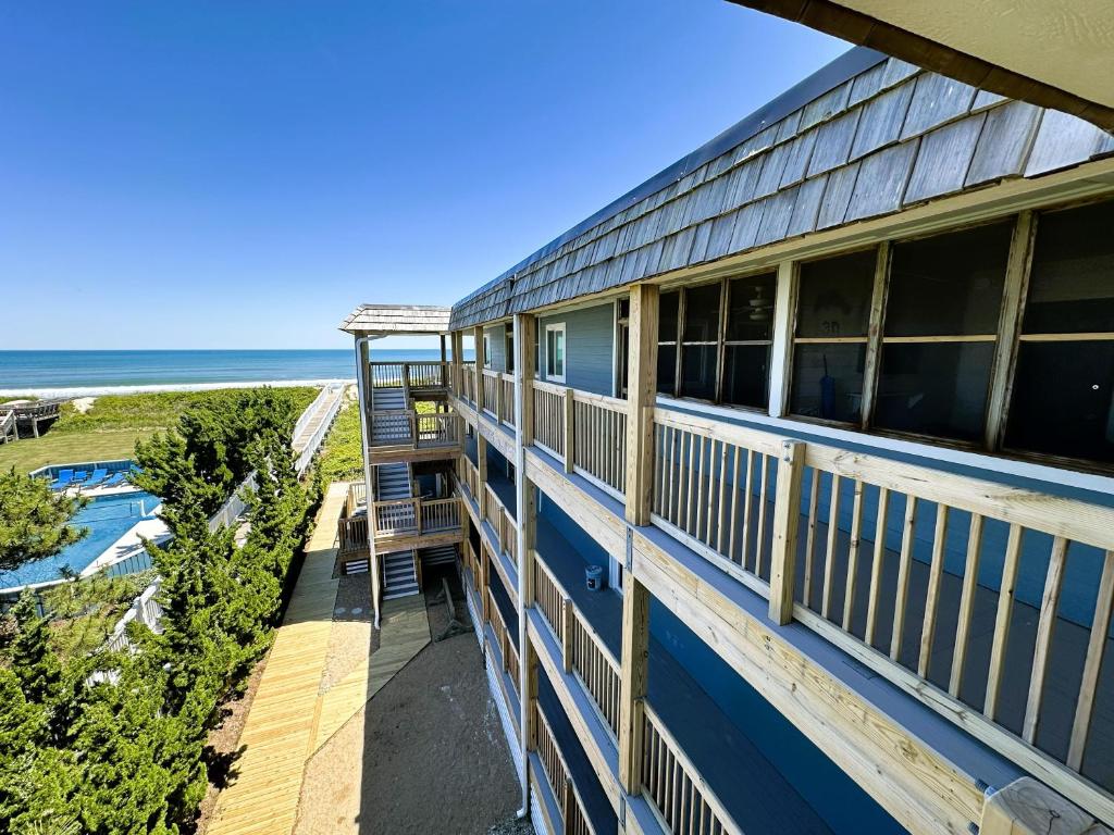 a balcony of a house with a ladder overlooking the ocean at D134B- Vacay Vibes in Duck