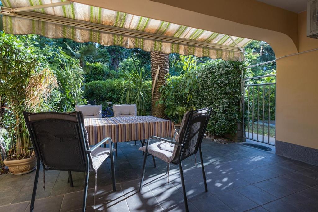 a patio with a table and chairs in a garden at Green Oasis by the Sea in Koper