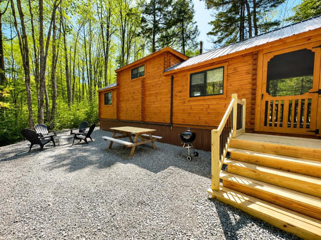 a cabin with a staircase and a picnic table and chairs at Cozy Coastal Cabin 1 in Steuben