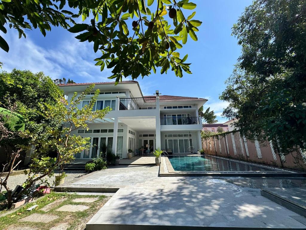 a house with a swimming pool in front of it at An Nhien Mercury Villa & Resort in Phú Quốc