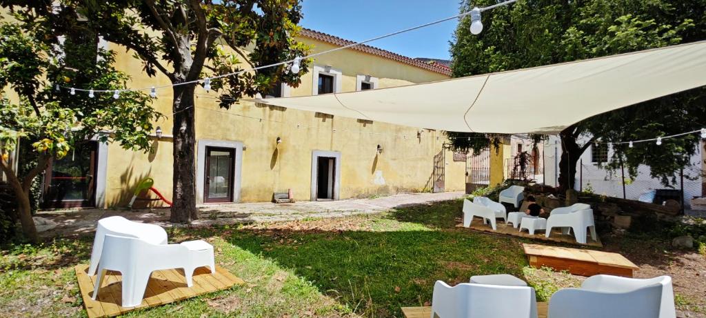 a group of white chairs in a yard with a building at Palazzo Cafarelli in Laureana Cilento