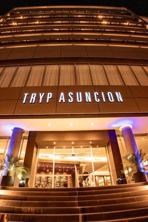 a building with stairs in front of a shopping center at Tryp by Wyndham Asuncion in Asunción
