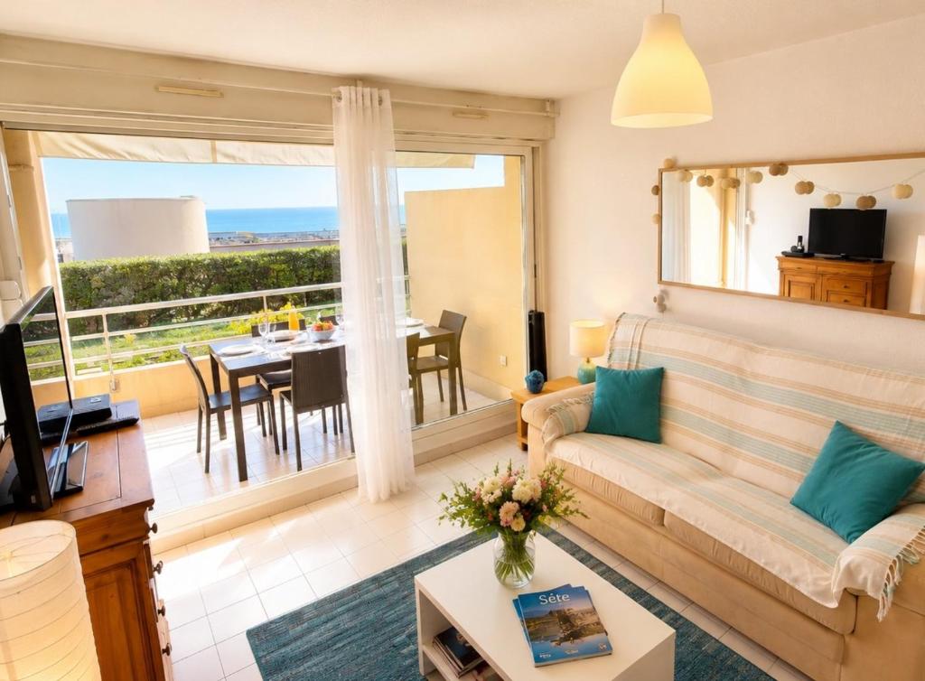 a living room with a couch and a large window at Lagune Azur – Séjour cosy vue mer piscine Wi-Fi in Sète