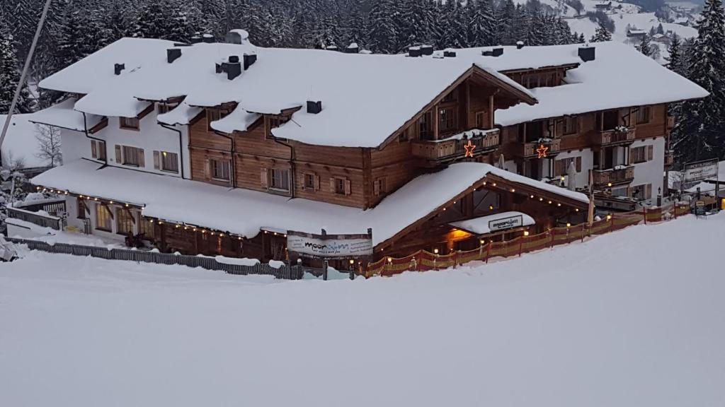 a large building with snow on top of it at Panorama Chalets am Pass Thurn in Mittersill