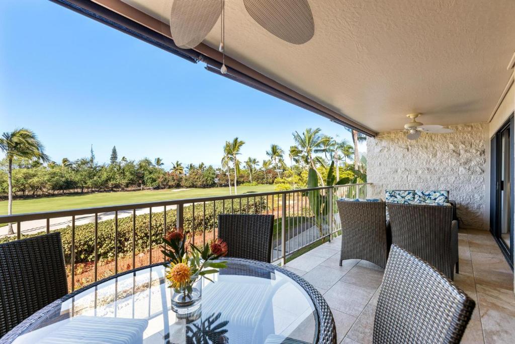 a patio with a glass table and chairs on a balcony at Keauhou Punahele#D-206 in Kailua-Kona