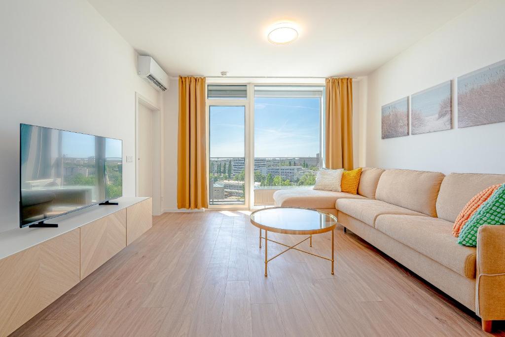 a living room with a couch and a flat screen tv at Apartment TOMI - Olivia Residence in Trnávka