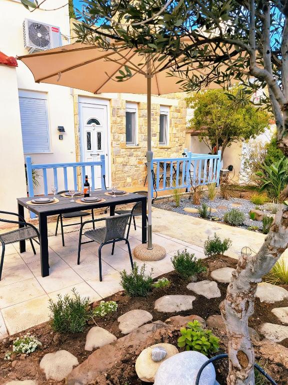 a picnic table with an umbrella in a garden at Myrtos Olive Seaside Villa in Myrtos
