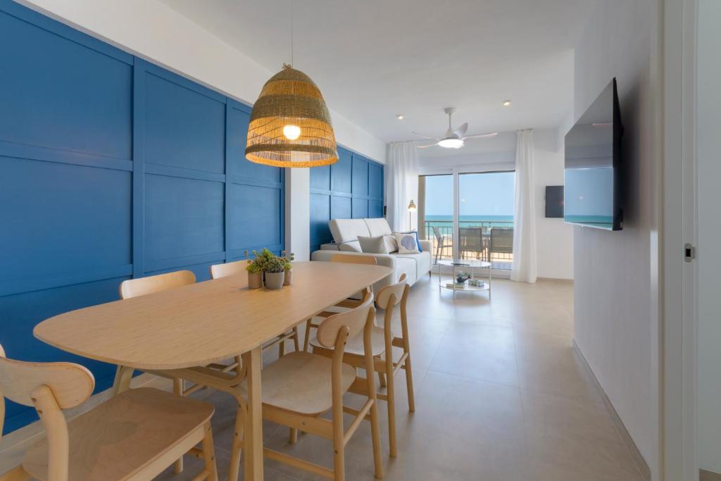 a dining room and living room with a table and chairs at AG LAS SIRENAS in Playa de Gandia