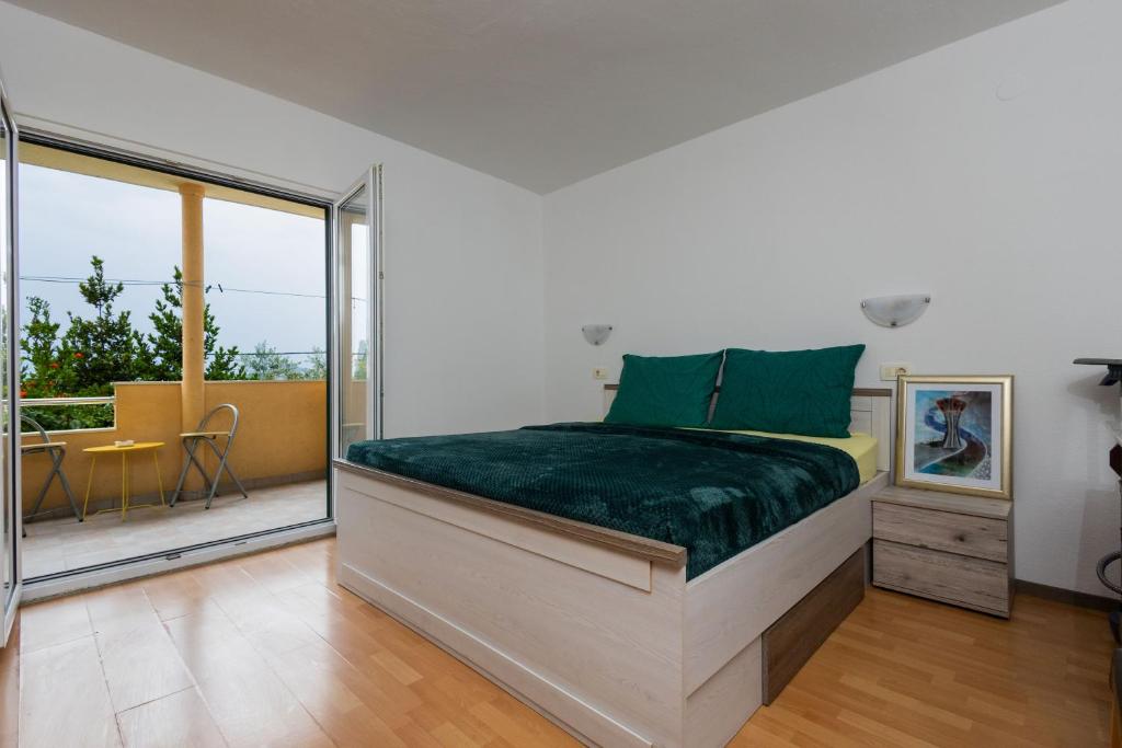 a bedroom with a bed and a balcony at Sea Breeze Retreat in Strožanac