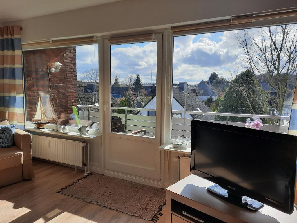 a living room with a large window and a flat screen tv at Ferienwohnung Oelstorf in Eckernförde