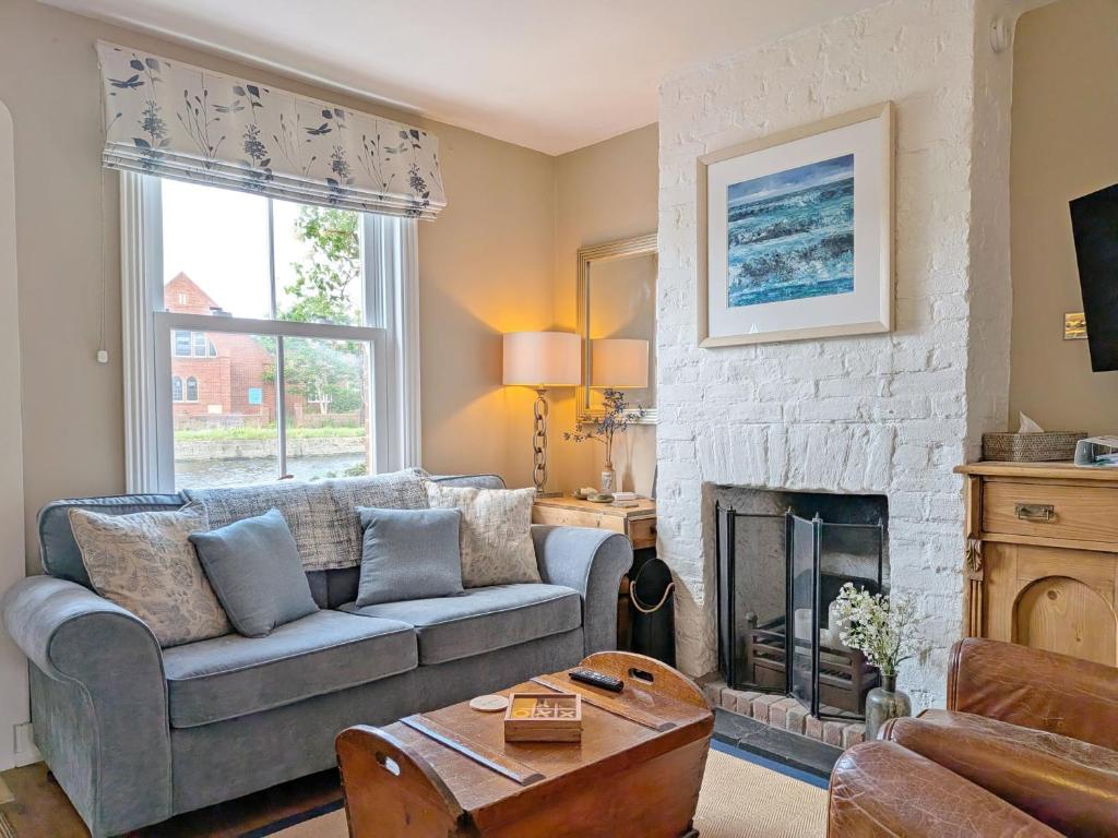 a living room with a couch and a fireplace at Compass Cottage , Emsworth in Emsworth