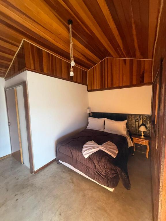 a bedroom with a bed with a bow on it at Rancho do Ipês in Campos do Jordão