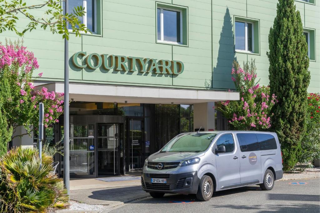 a silver van parked in front of a building at Courtyard by Marriott Toulouse Airport in Toulouse