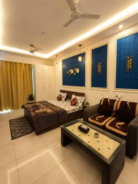a living room with a couch and a table at Darshana Studios#Cozy in Noida