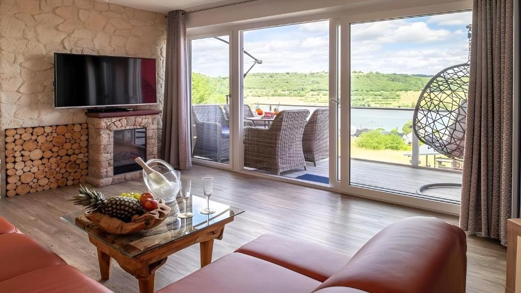 a living room with a couch and a table with a fireplace at Exclusiv Apartment - Seepanorama in Schalkenmehren