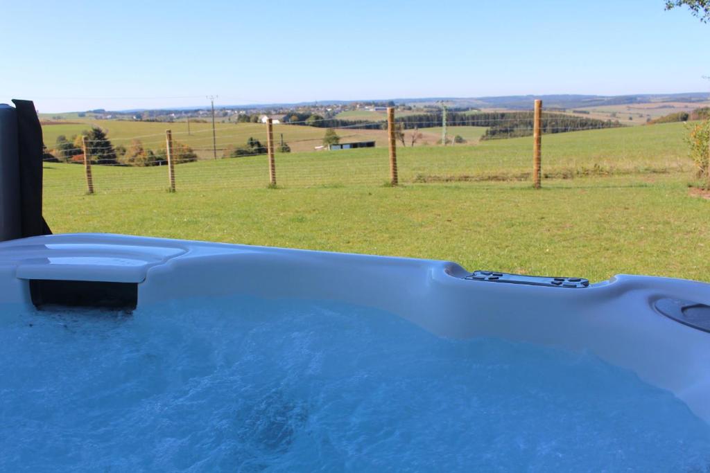 a hot tub with a view of a field at Eifel Dream Ardennenblick in Kobscheid