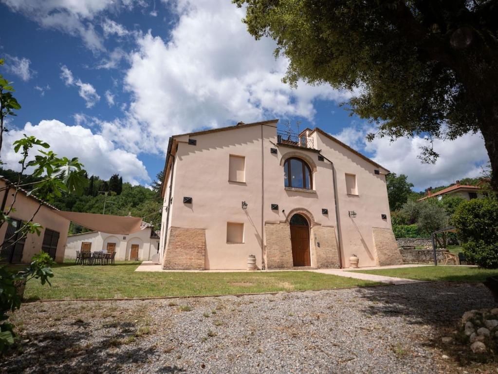 an exterior view of a large white building at Private Villa San Luigi in Sarteano