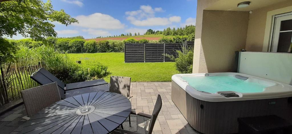 a patio with a hot tub and an umbrella at Eifel Dream Casa29 in Burbach
