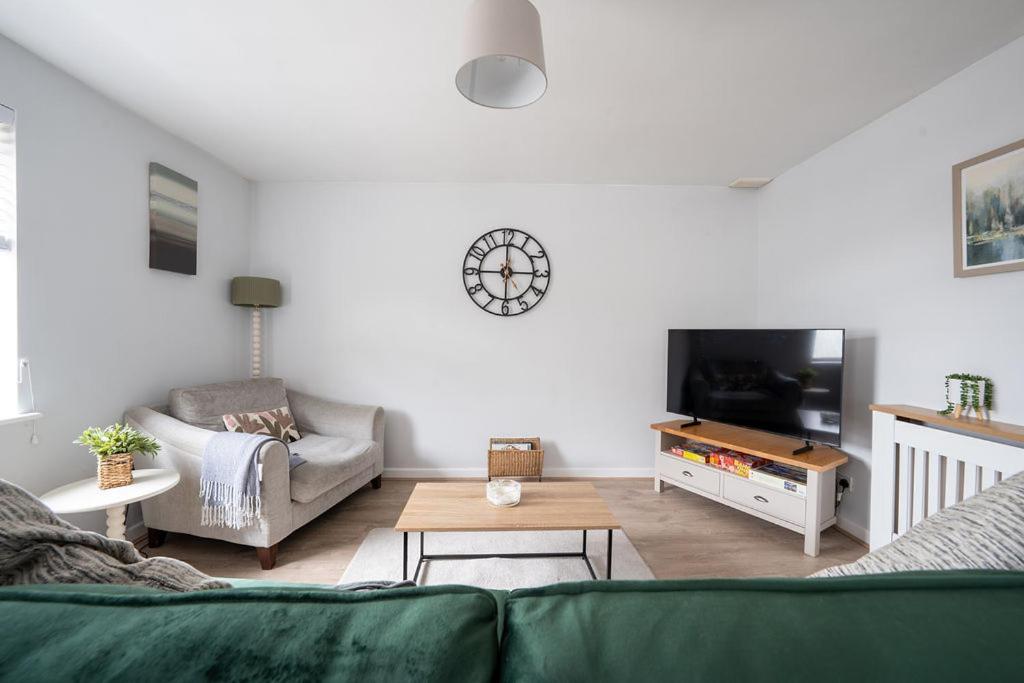 a living room with a couch and a tv at Stoops Hall - 2 bed first floor apartment in Garstang