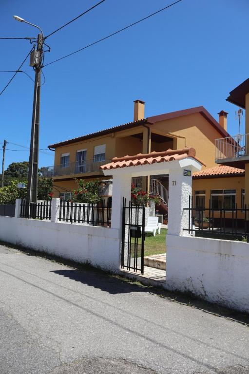 a house with a white fence in front of it at Vivenda Atlantico in Vila Praia de Âncora