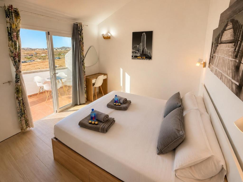 a bedroom with a large white bed and a couch at Sunny Bungalow with Pool & Patio in Sonnenland By Canarias Prime Homes in Maspalomas
