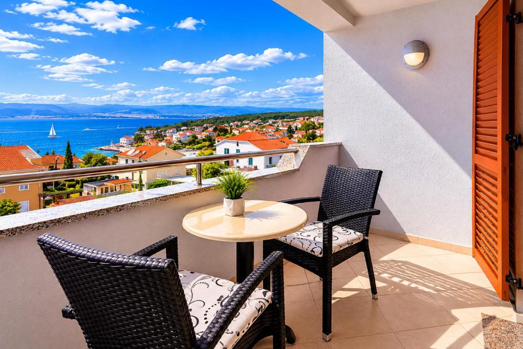 a balcony with a table and chairs and a view at Apartments Kvarner 2 in Malinska