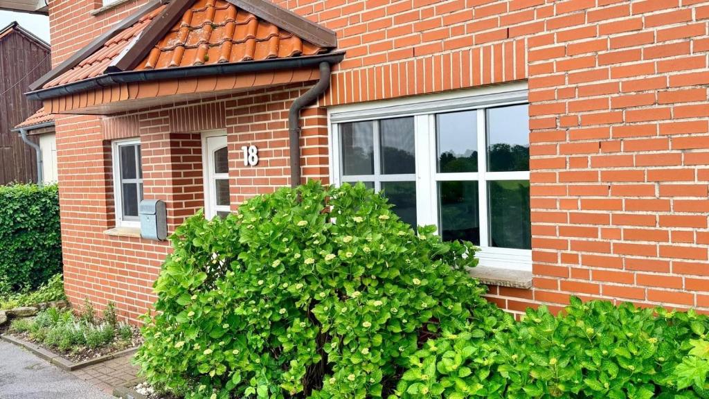 a brick house with a bush in front of a window at Longinus Quartier in Havixbeck