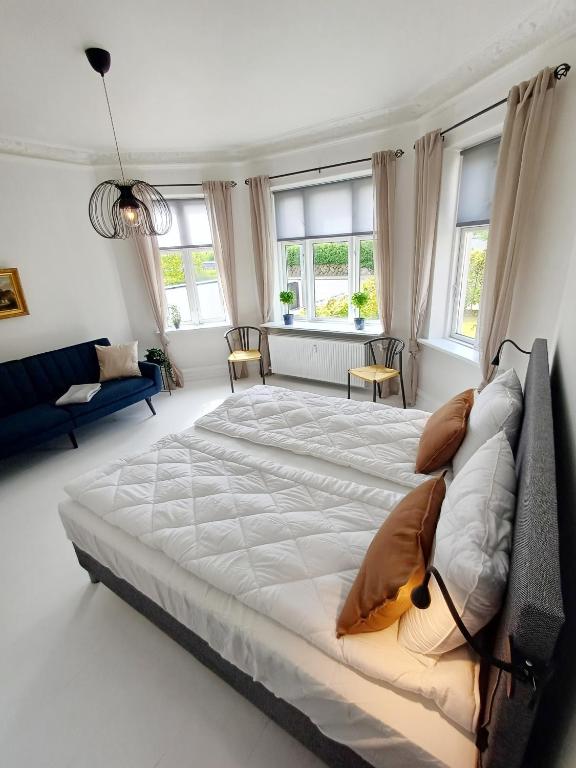 a large bed in a white room with windows at Exclusive Luxury Apartment with free private parki in Aalborg