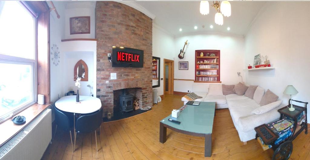 a living room with a couch and a fireplace at FREE DOG STAY - LARGE APARTMENT - FREE PUBLIC PARKING BEDROOM TV, WALK in SHOWER - FULL Kitchen - NETFLIX - Super Fast WiFi - DVD's-Welcome Tray - No Deposits - Just Meters from Gavin n Stacey Film House in Barry