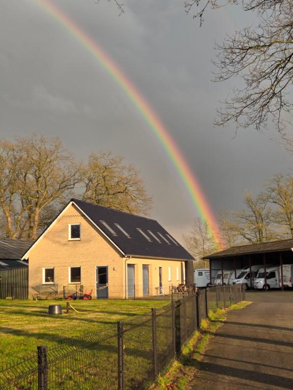 a rainbow in the sky over a house at Erve Ther Maet in Weerselo