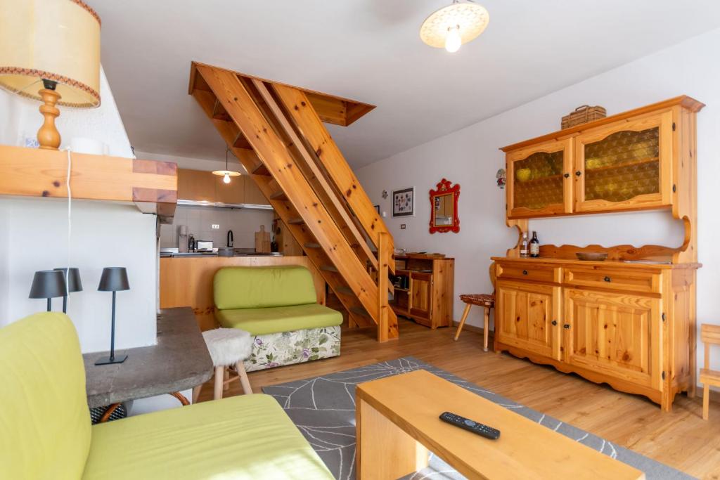 ein Wohnzimmer mit Treppe und Küche in der Unterkunft Ciasa pe de Bosc in Mazzin