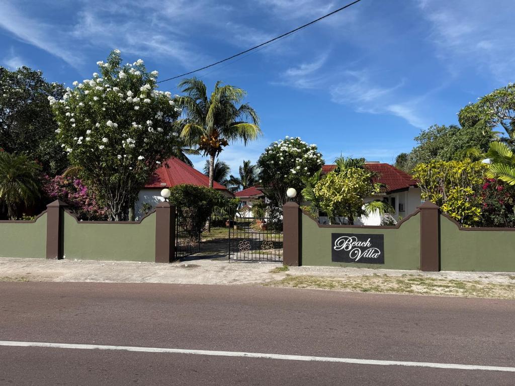 a house with a sign on the side of a street at Beach Villa Guesthouse in Grand Anse