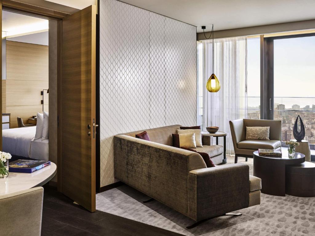 a hotel room with a couch and a bedroom at Fairmont Quasar Istanbul Hotel in Istanbul