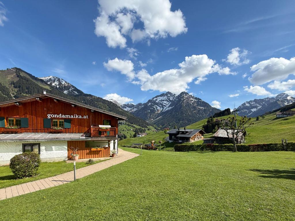 a house in a field with mountains in the background at Bi-dr-Gondamaika in Hirschegg