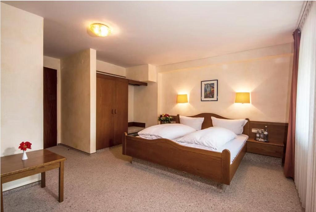 a bedroom with a large bed with white pillows at Hotel Bürkls Kirnbachtal in Niefern-Öschelbronn