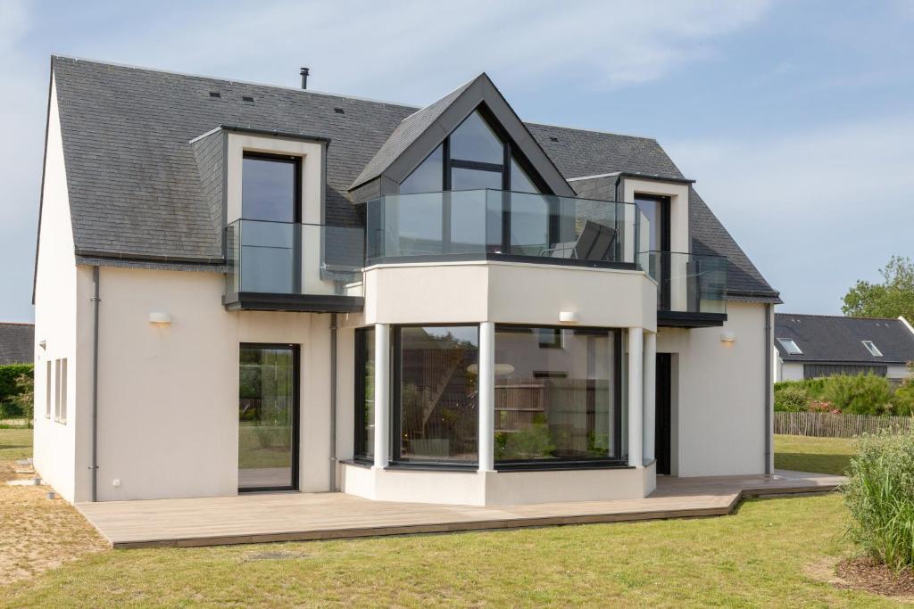 a house with glass windows and a roof at Aux flots de la Torche, 3ch in Penmarch