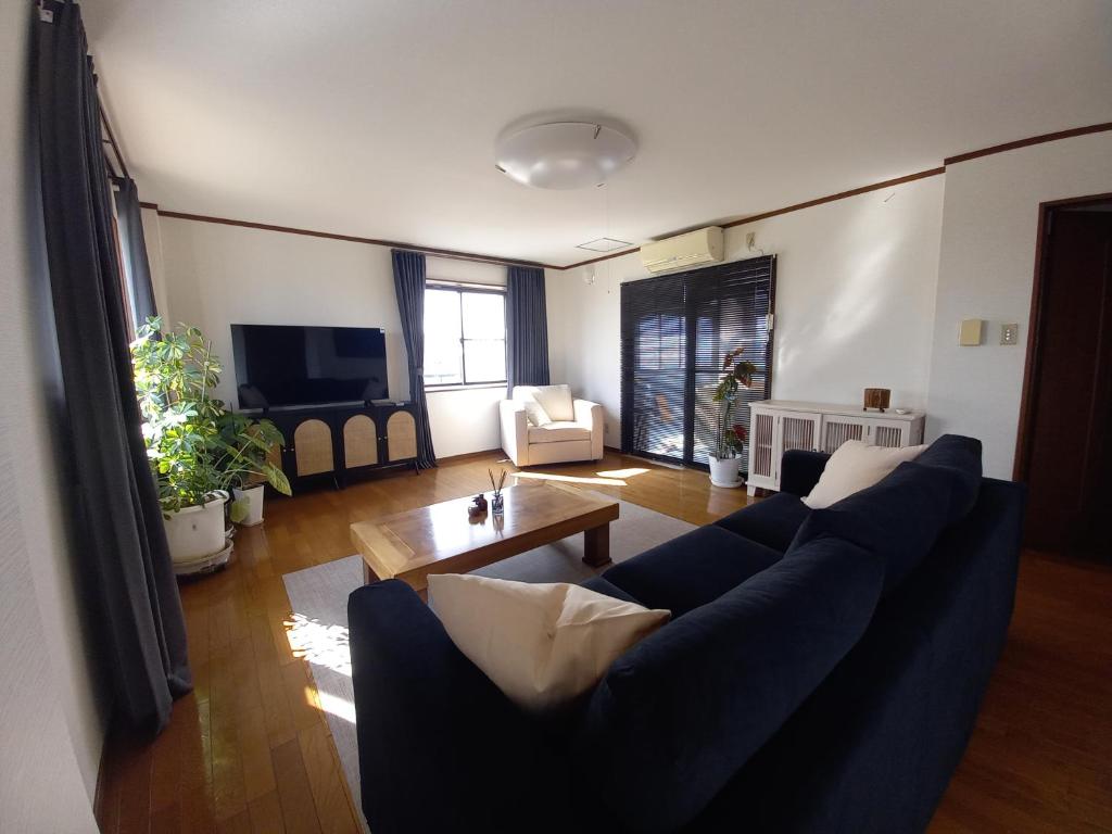 a living room with a blue couch and a table at Villa Nami in Kashima