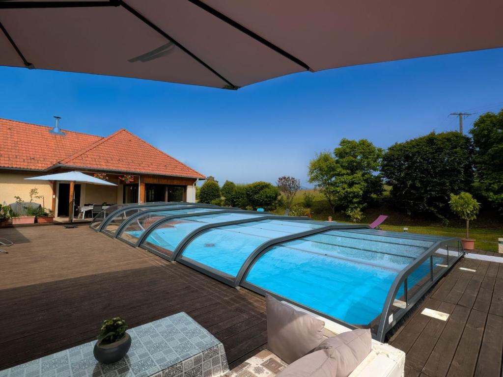 a large swimming pool with a glass roof at Le Clos des Aulnes in Anould