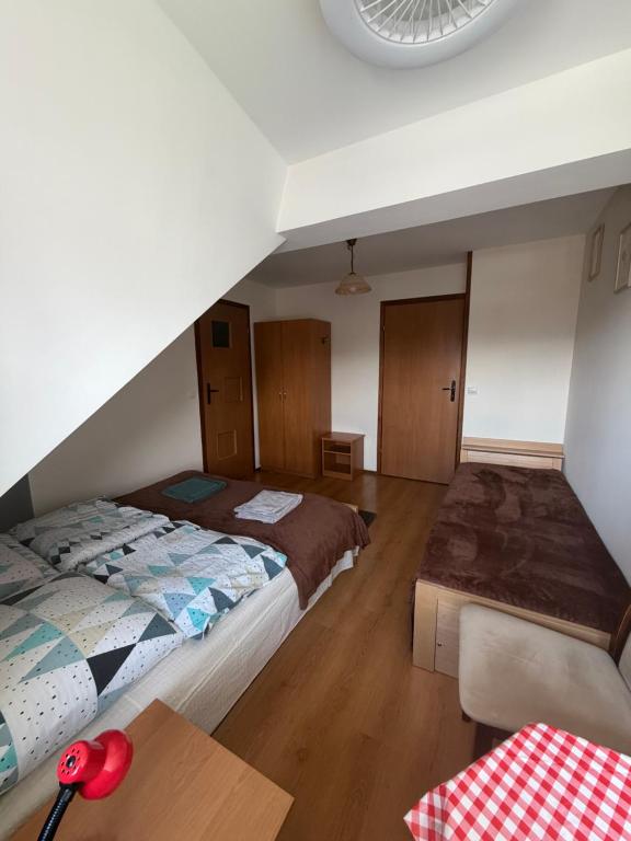 a bedroom with a bed and a table at Atticapartament in Kluszkowce
