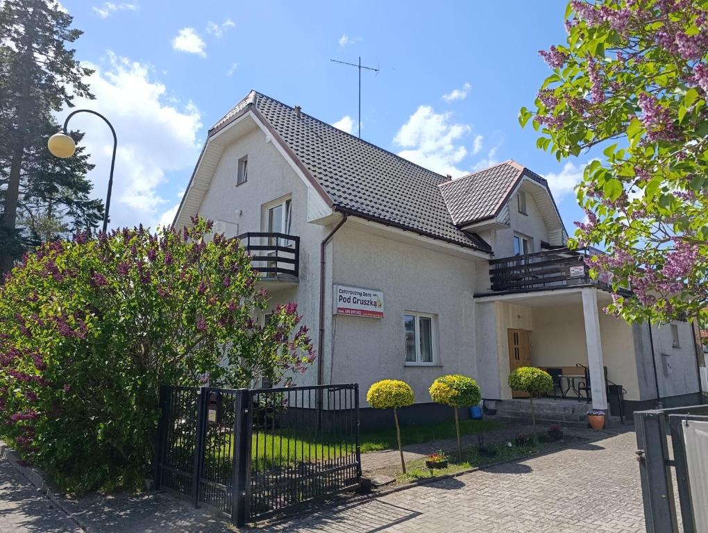 a white house with a fence in front of it at Dom Pod Gruszką in Pobierowo