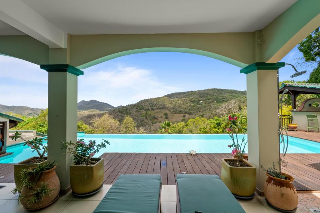 a view of a swimming pool from the porch of a house at Studio Lili in Le Diamant