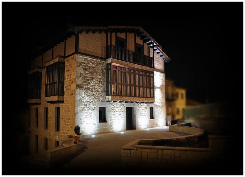 a large brick building with lights on it at night at Posada Dos Aguas in Covaleda