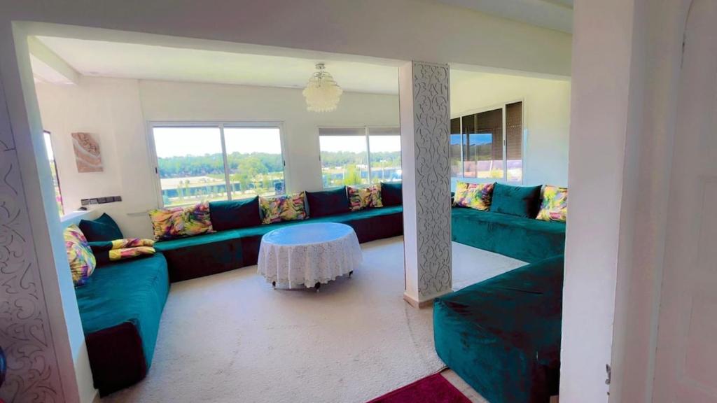 a living room with blue couches and a table at Meditation house in El Jadida