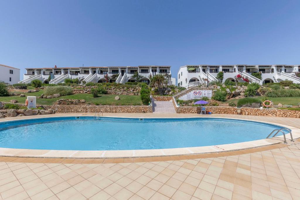 a large swimming pool in front of a building at Calma Menorca in Arenal d'en Castell