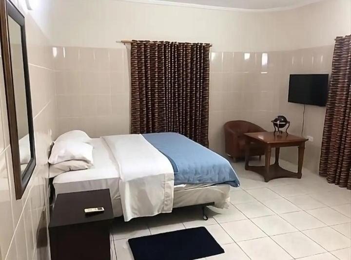 a bedroom with a bed and a desk and a television at Studio Apt-Osu in Christiansborg
